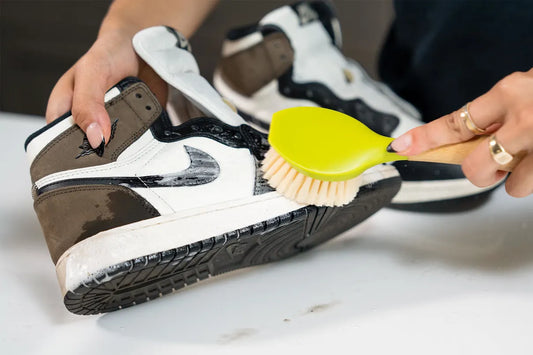 using a gentle scrub brush to clean jordan 1 mochas with a bubbly shoe cleaner