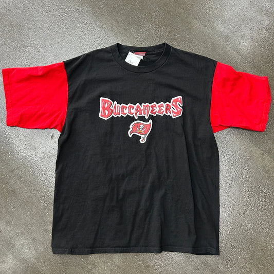 Black t-shirt with red sleeves and 'Buccaneers' logo on a gray surface