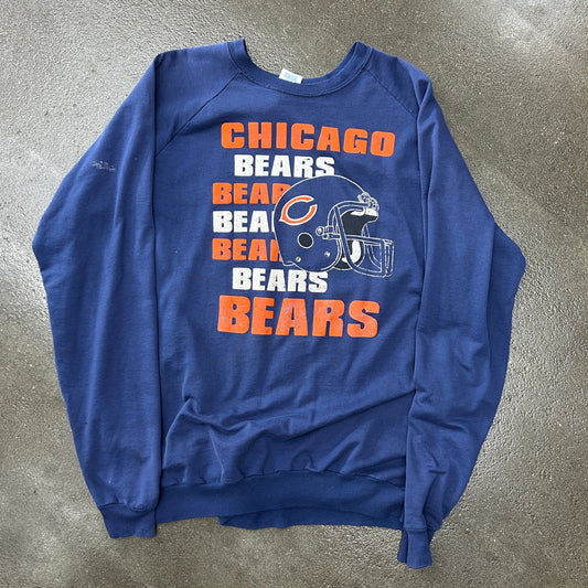 Blue sweatshirt with Chicago Bears graphics on a gray concrete surface